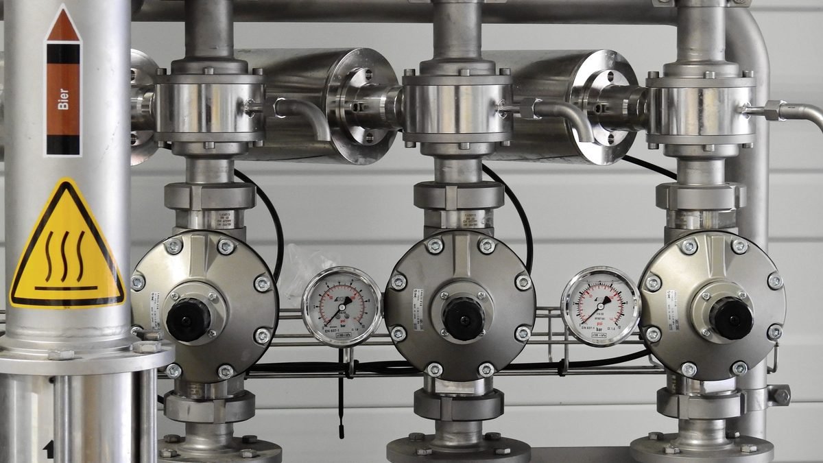 Tubulação industrial em aço inox com manômetros e válvulas