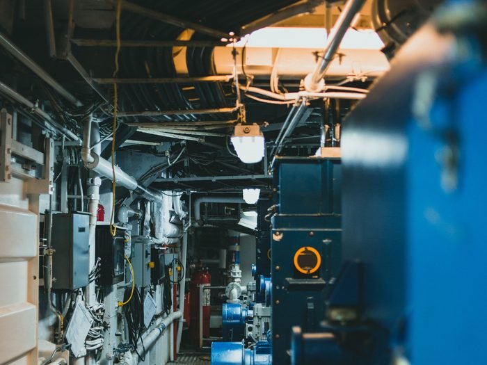 Sala de caldeiras industrial com tubulações e painéis