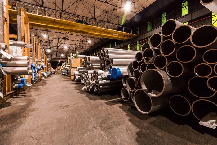 Tubos de aço empilhados em galpão industrial